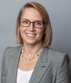 Professional woman wearing glasses and a gray blazer